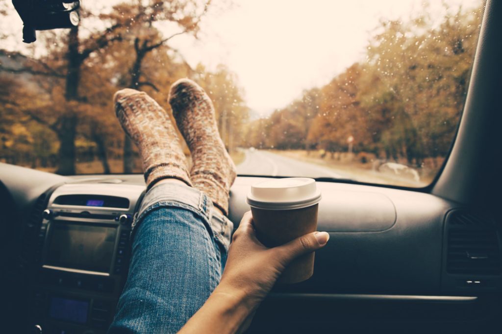 image of legs on a dashboard with a coffee